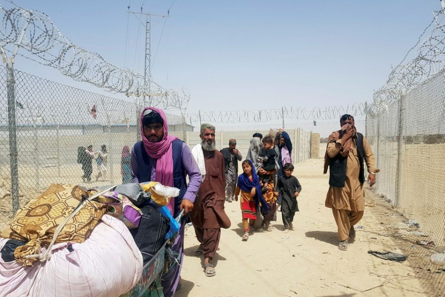 A family from Afghanistan walk next to fence to cross into Pakistan at the Friendship Gate crossing point, in the Pakistan-Afghanistan border town of Chaman, Pakistan on September 6, 2021 — Reuters/Files