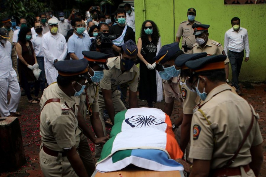 Police personnel carry the coffin of deceased Air India pilot Deepak Sathe as family members look on during his funeral in Mumbai, India on August 11, 2020 — Reuters/Files