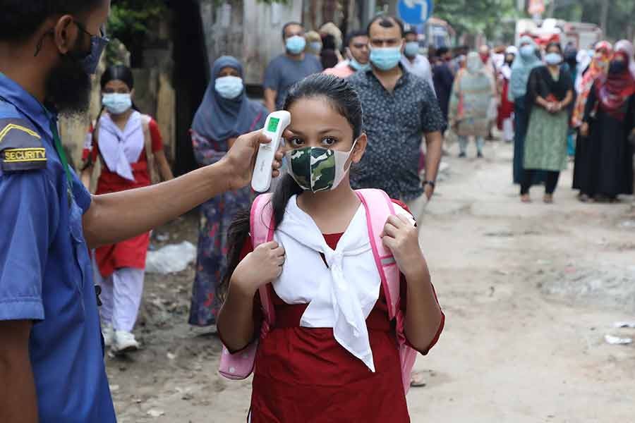 Students entering Banglabazar Government Girls High School in Dhaka on Sunday, the day of reopening of educational institutions after a 17-month closure due to COVID-19 pandemic –FE file photo