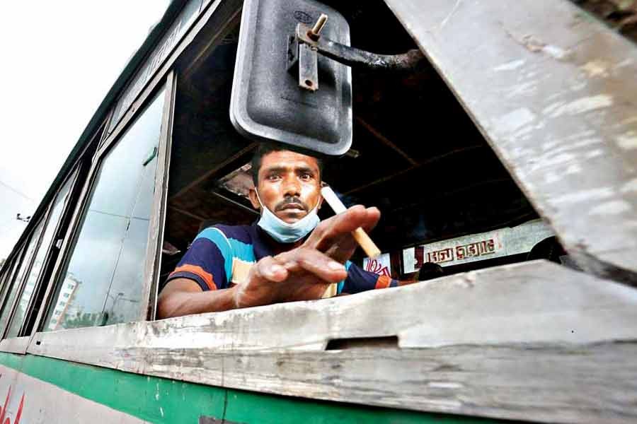 With his mask hanging under his chin, a bus driver smoking while driving, which poses health risks to the passengers. The photo of the driver flouting the health safety rules was taken in Khilgaon area of the city amid COVID-19 pandemic last year —FE file photo