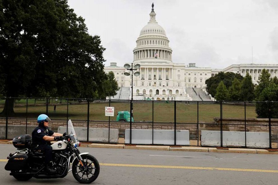 A US Capitol Police officer patrols the unscalable fence erected around the Capitol ahead of an expected rally Saturday in support of the Jan 6 defendants in Washington, US September 17, 2021. REUTERS/Jonathan Ernst