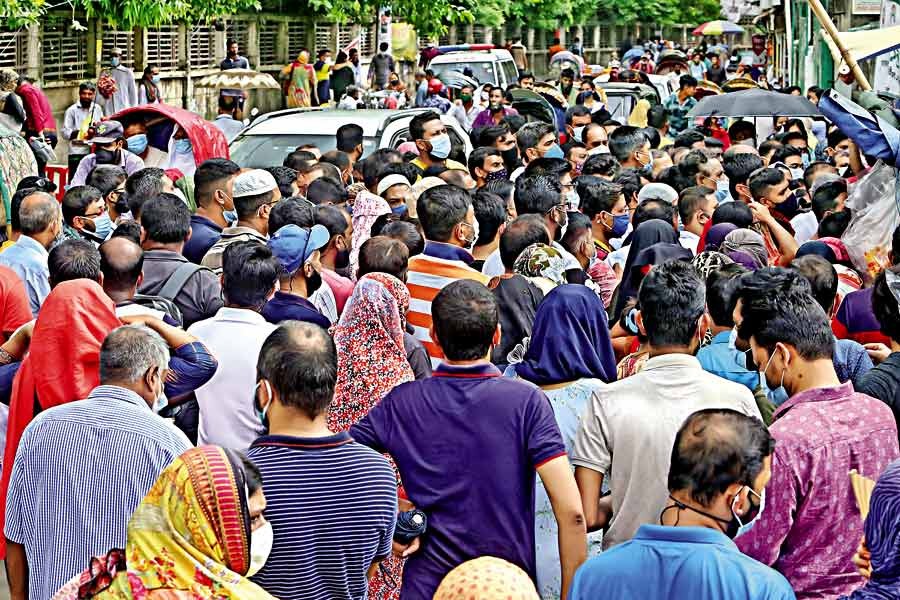 People gather on the road in front of the Uttar Mugda Matrisadan in the city on Saturday to get Covid jabs. However, the social distancing norm is not being followed, leaving them at the risk of contracting the virus. —FE photo