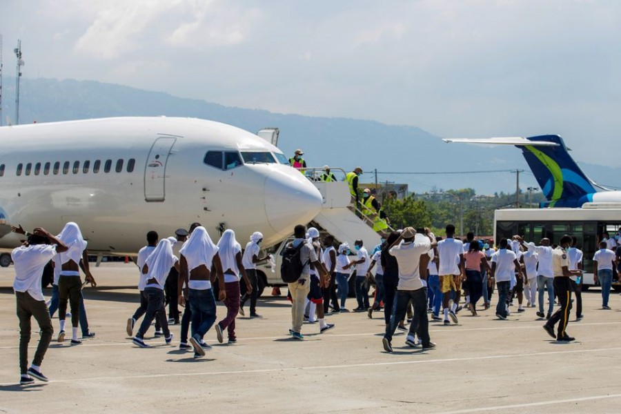 Haitian migrants board an airport bus aftter US authorities flew them out of a Texas border city after crossing the Rio Grande river from Mexico, at Toussaint Louverture International Airport in Port-au-Prince, Haiti September 21, 2021. REUTERS/Ralph Tedy Erol