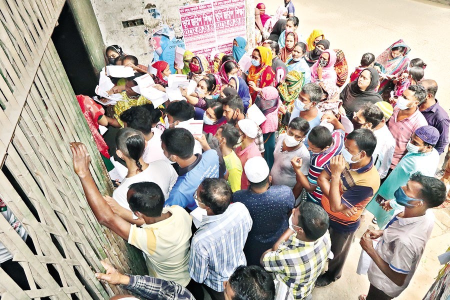 People wait outside a 'Surjer Hashi' clinic at Dayaganj in the city on Tuesday to get Covid vaccine shots during a special nationwide vaccination programme marking the 75th birthday of Prime Minister Sheikh Hasina — FE photo