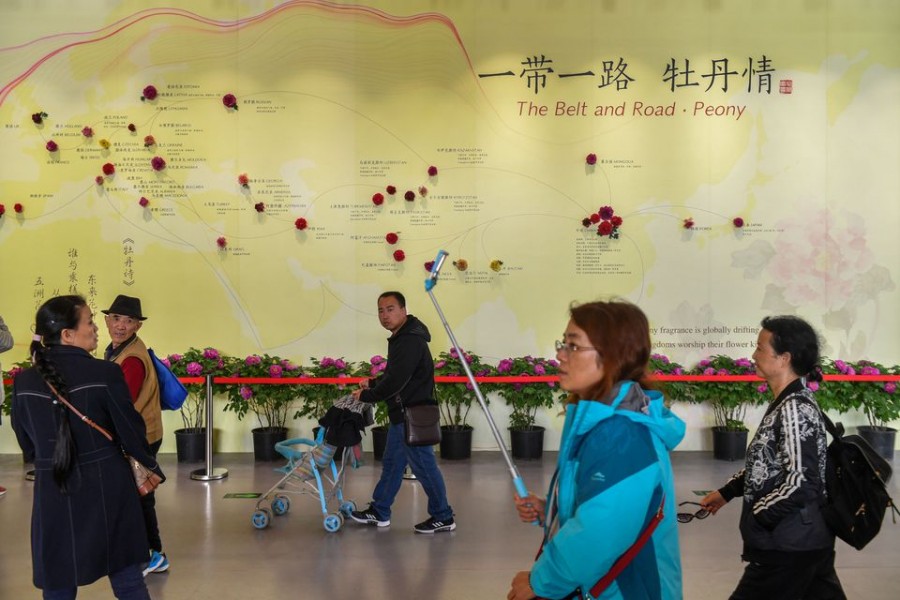 Visitors walk past a wall with a map showing the species of peony in Belt and Road Initiative (BRI) countries, at horticultural exhibition Beijing Expo 2019, in Beijing, China April 29, 2019. Picture taken April 29, 2019. REUTERS/Stringer