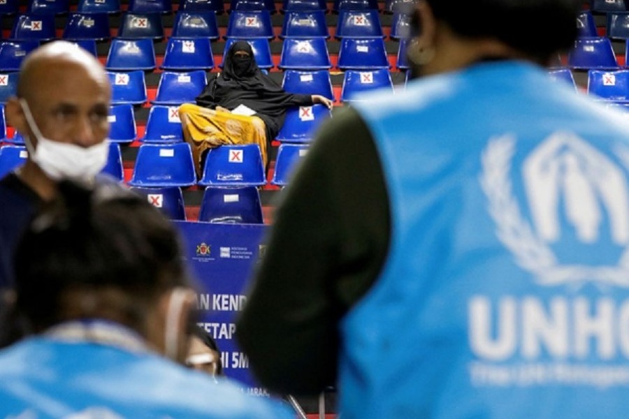 A woman waits inside a sports hall to receive a coronavirus disease (COVID-19) vaccine dose during a mass vaccination program for asylum seekers and refugees in Jakarta, Indonesia, October 7, 2021. Reuters