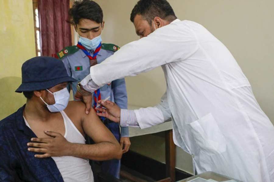 A healthcare worker administering a COVID-19 vaccine dose to a student at Dhaka University’s Martyred Intellectual Dr Muhammad Murtaza Medical Centre on Monday –bdnews24.com file photo