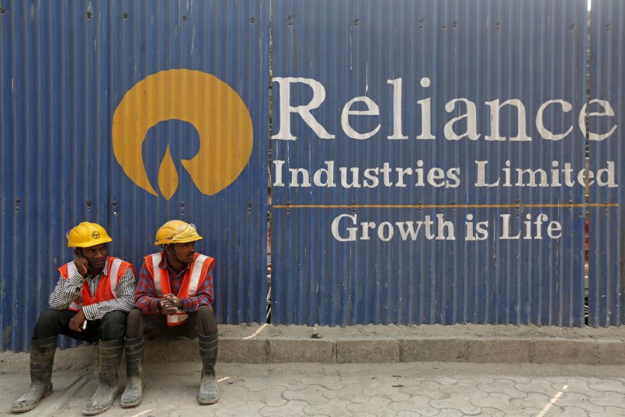 Labourers rest in front of an advertisement of Reliance Industries Limited at a construction site in Mumbai, India, March 2, 2016. REUTERS/Shailesh Andrade/File Photo