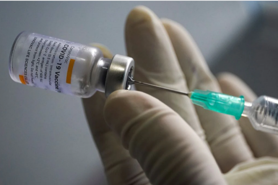 A health worker holds a syringe and a vial of the Sinovac coronavirus disease (COVID-19) vaccine at a market in Bangkok, Thailand, March 17, 2021. REUTERS/Athit Perawongmetha