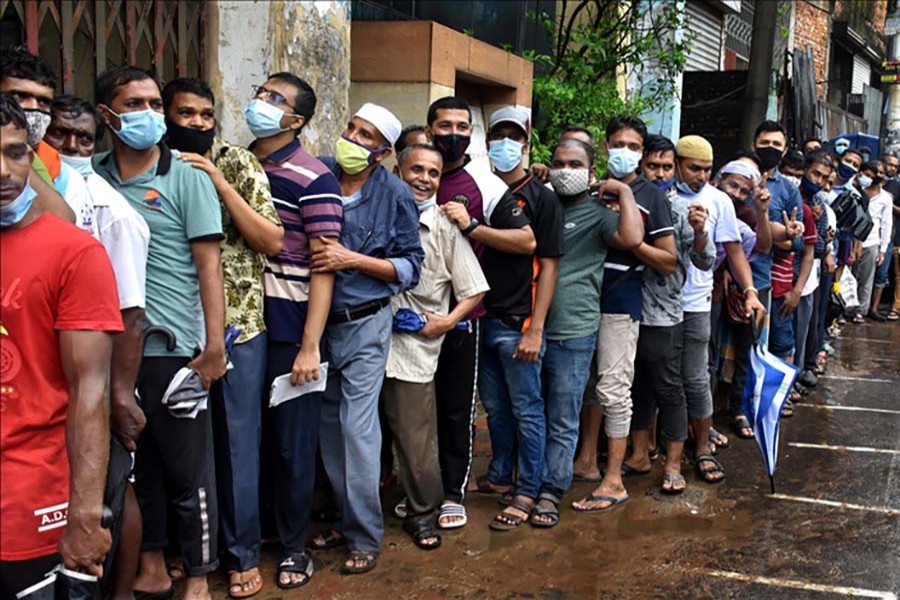 People wait in line for about 7-8 hours as the mass vaccination starts at the Chittagong General Hospital, in Chittagong, Bangladesh.  PHOTO - Anadolu Agency