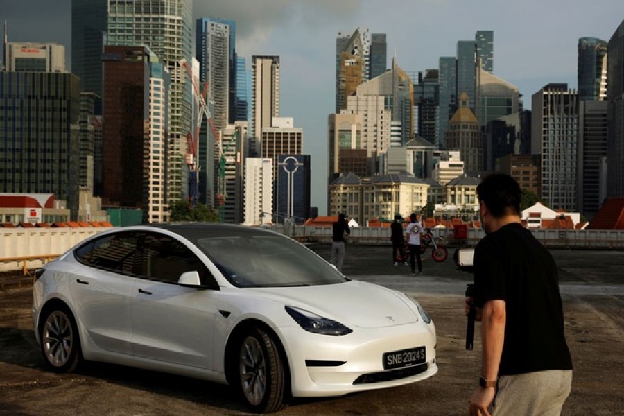 Tesla car owner Tim Shim, 42, films an “unboxing” video of his new Model 3 car in Singapore October 25, 2021. REUTERS