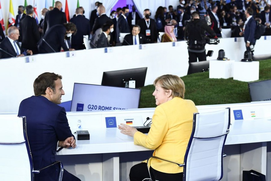 French President Emmanuel Macron speaks with German Chancellor Angela Merkel before the opening session of the G20 leaders summit in Rome, Italy October 30, 2021. Brendan Smialowski/Pool via REUTERS