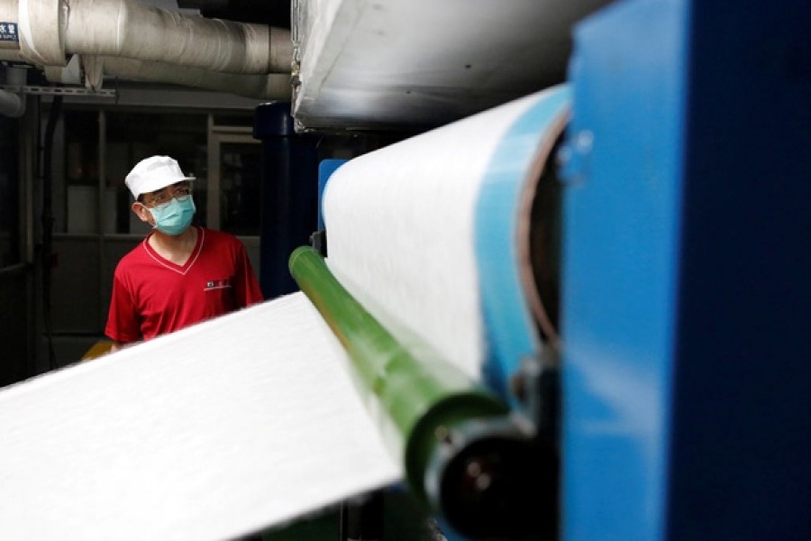 Staff member works inside a non woven filter fabric factory, where the fabric is used to make surgical face masks, in Taoyuan, Taiwan, March 30, 2020 – Reuters/Ann Wang