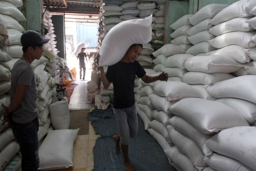 A worker carries a bag of rice to a store outside Hanoi November 26, 2013. Vietnam submitted the lowest price to supply 500,000 tonnes of rice to the Philippines, beating Thailand's offer for grain to boost stocks depleted by Typhoon Haiyan, Manila's grain procurement agency said on Tuesday. REUTERS/Kham