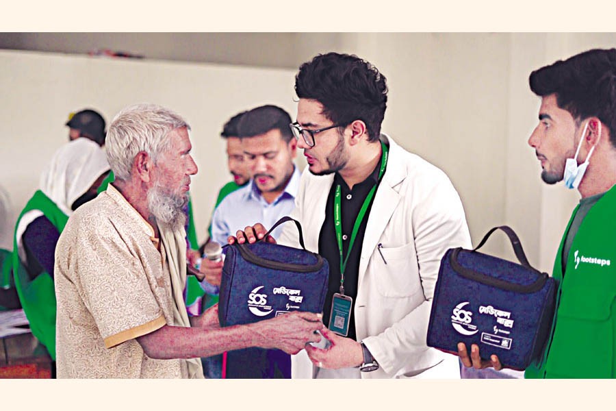 Volunteers of Footsteps Bangladesh handing over medical boxes to villagers as part of the SOS programme