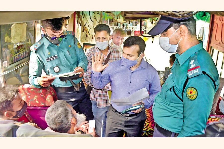 In the wake of allegations of charging higher fares than the agreed rates following a hike in diesel prices, an executive magistrate of the Dhaka Metropolitan Police talking to passengers of a bus while conducting a mobile court in front of the IDB Bhaban in the capital on Wednesday — Focus Bangla