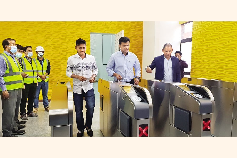 Bangladesh Cricket Board selectors Habibul Bashar and Abdur Razzak and current national cricketer Mehidy Hasan Miraz are seen using Rapid Pass to enter the metro rail station at Uttara in the city on Tuesday. The trio joined an event there to witness the trial run of the train — FE photo by Munima Sultana