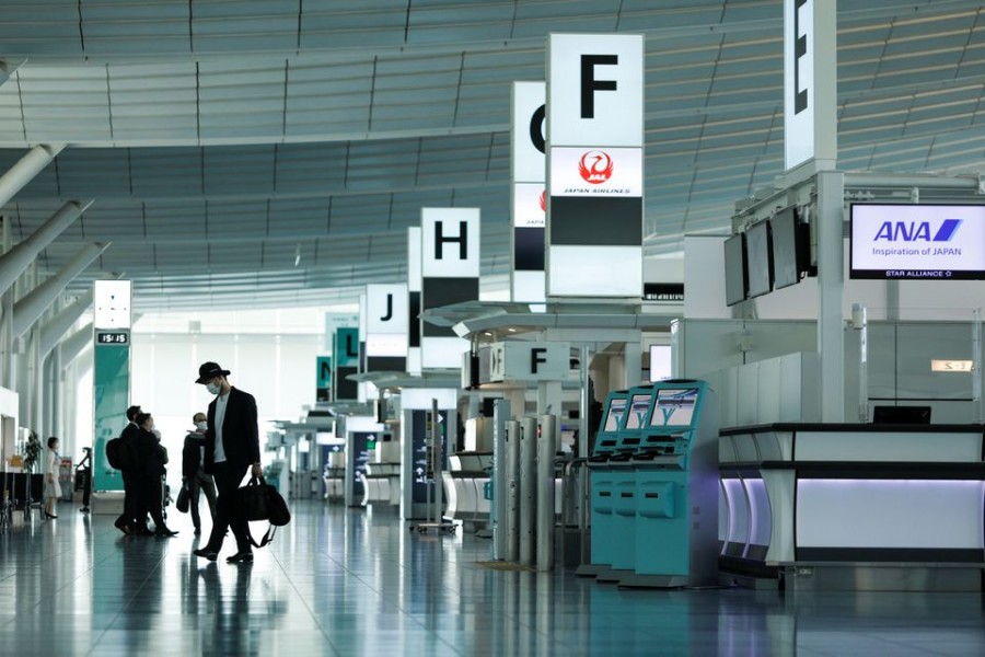 Passengers wearing protective face masks, amid the coronavirus disease (COVID-19) pandemic, walk at the Haneda airport, in Tokyo, Japan June 13, 2021. REUTERS/Androniki Christodoulou