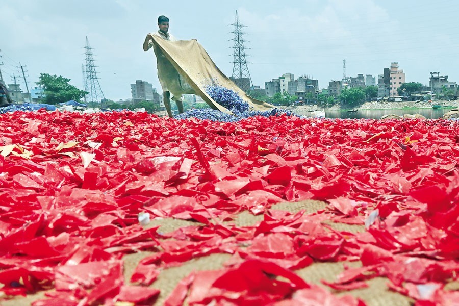 Pieces of discarded plastic items have been spread on the embankment at Lalbagh in the city to dry as part of a plastic recycling process. A number of plastic recycling workshops located in the area are engaged in plastic recycling, thereby contributing to the economy as well as protection of the environment. The photo was taken on Friday —- FE photo by Shafiqul Alam