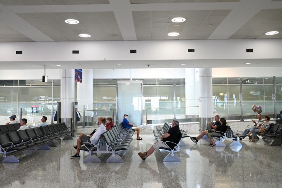 People sit in the arrivals section of the international terminal of Kingsford Smith International Airport the morning after Australia implemented an entry ban on non-citizens and non-residents intended to curb the spread of the coronavirus disease (Covid-19) in Sydney, Australia on March 21, 2020 — Reuters/Files