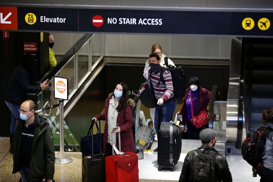 People enter the baggage claim area from the international arrivals terminal as the US reopens air and land borders to coronavirus disease (Covid-19) vaccinated travellers for the first time since the Covid-19 restrictions were imposed, at Sea-Tac Airport in Seattle, Washington, US on November 8, 2021 — Reuters/Files