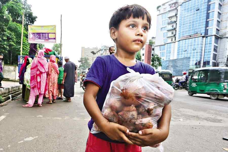 A child is returning home with onions bought at a subsidised price from a TCB sales point in the Fakirapool area of the city. The photo was taken on October 14 this year. –FE file photo