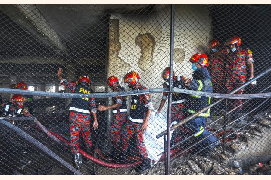 Firefighters work at the fire site of a juice factory in Narayanganj on the outskirts of Dhaka, Bangladesh, on July 9, 2021. At least 52 people have died as a huge fire raged for a second day in the juice factory in Narayanganj. 	—Xinhua Photo