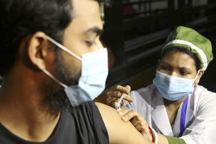 A health worker administers a Covid-19 vaccine shot to a young  man at a hospital in Dhaka — Focus Bangla file photo