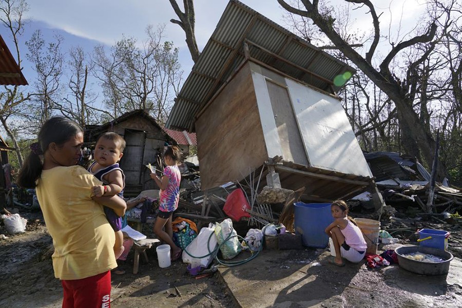 Residents stand amid damaged homes following Typhoon Rai in Talisay, Cebu province, central Philippines on December 18, 2021 — AP photo