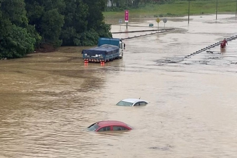 Partially submerged cars are seen on a flooded road in Shah Alam, Malaysia December 18, 2021, in still image obtained from social media video. Courtesy of Ashraf Noor Azam/via REUTERS