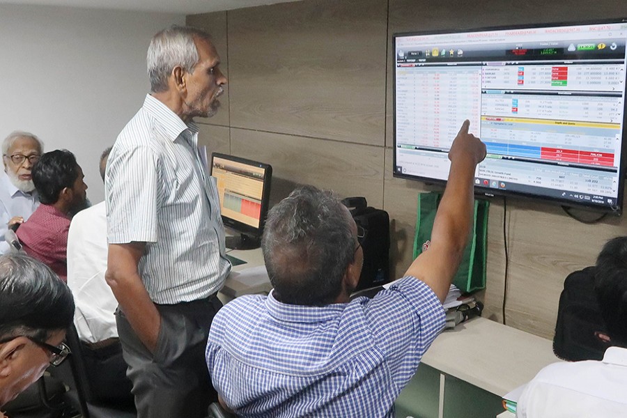 Investors react while monitoring stock price movements on TV and computer screens at a brokerage house in the capital city — FE/Files