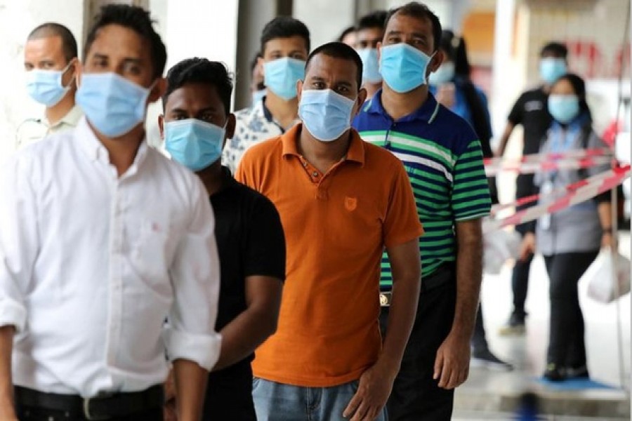 Foreign workers wait in line to be tested for the coronavirus disease (Covid-19) outside a clinic in Kajang, Malaysia October 26, 2020 – Reuters/Files