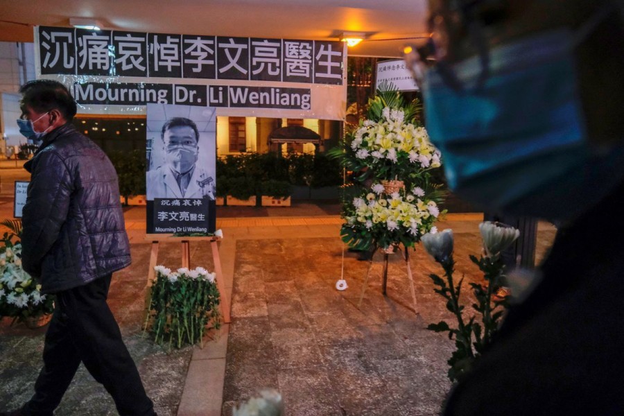 People wearing masks attend a vigil for late Li Wenliang, an ophthalmologist who died of coronavirus at a hospital in Wuhan, in Hong Kong, China February 7, 2020. REUTERS/Tyrone Siu/File Photo