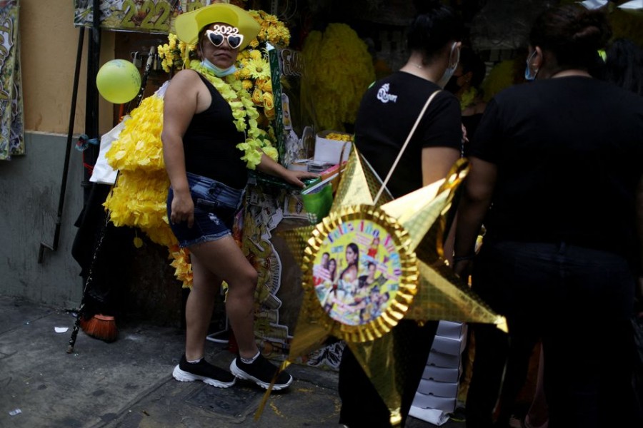 A vendor wearing products for the New Year's Eve waits for clients in a street market in Lima, Peru December 30, 2021. REUTERS/Pilar Olivares