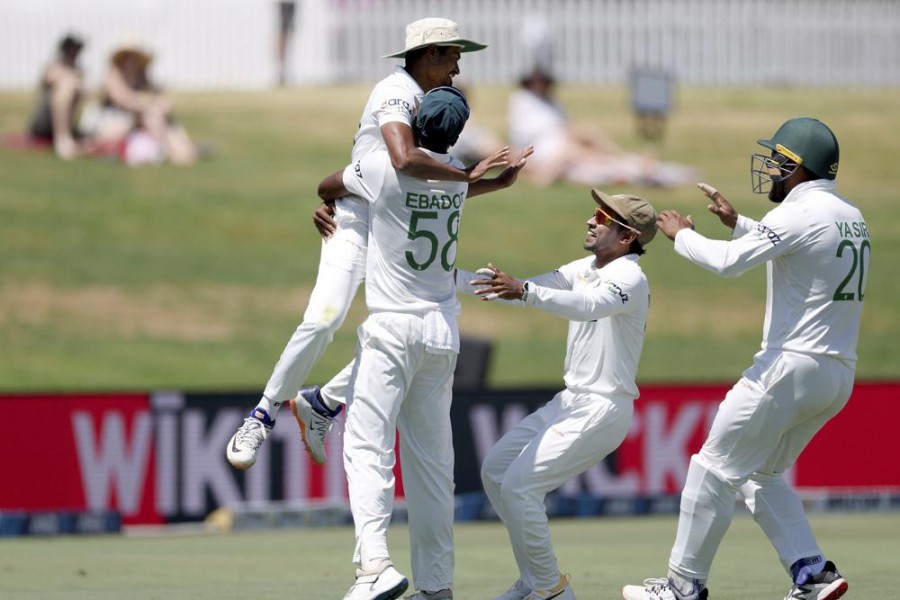 Bangladesh's Taijul Islam, top left, celebrates catching Blackcaps Trent Boult with team mates during play on day five of the first cricket test between Bangladesh and New Zealand at Bay Oval in Mount Maunganui, New Zealand on January 5, 2022 — Photosport via AP