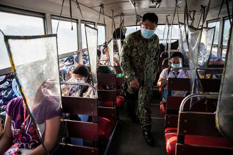 A policeman inspecting a bus passing through a checkpoint on the first day of a two-week lockdown to prevent the spread of the highly infectious coronavirus Delta variant, in Quezon City of Metro Manila in the Philippines on August 6 last year -Reuters file photo