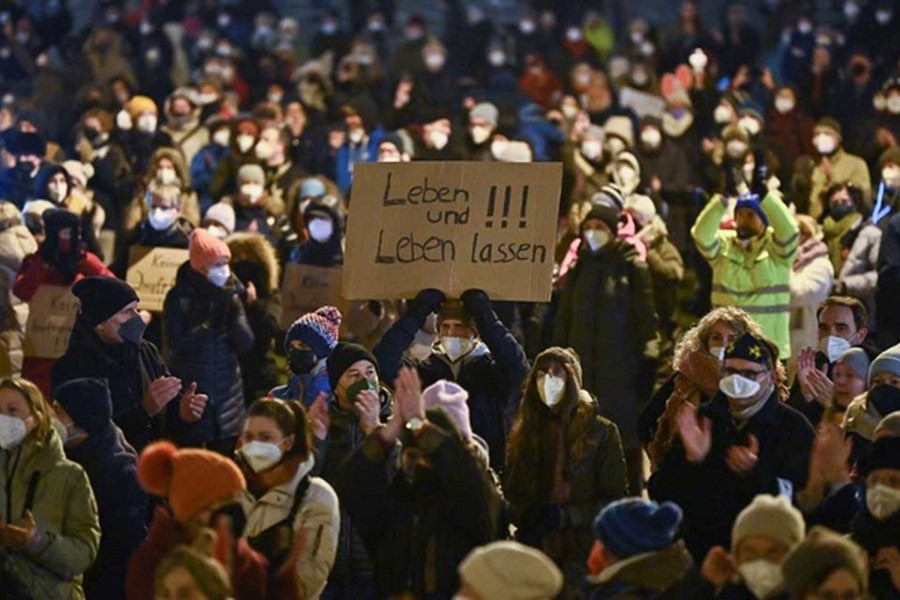 A demonstrator holds a sign during a protest against government measures to curb the spread of the coronavirus disease (COVID-19) at the Koenigsplatz in Munich, Germany, Jan 26, 2022. The sign reads "Live and let live". REUTERS/Lukas Barth