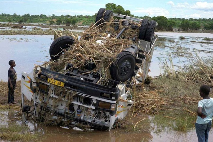 Locals look at a wreck washed away during Tropical Storm Ana on the flooded Shire river, an outlet of Lake Malawi at the village of Thabwa in Chikwawa district, southern Malawi, Jan 26, 2022. Reuters