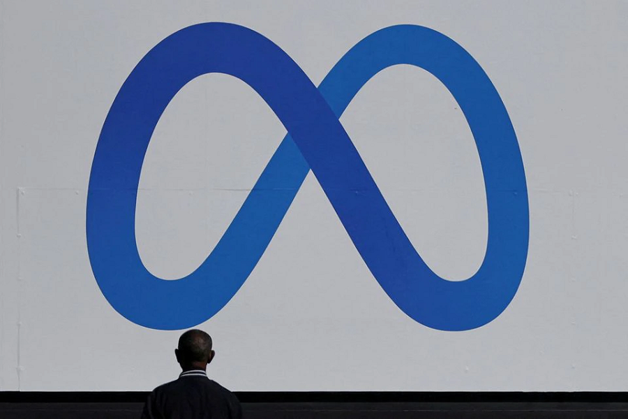 A man stands in front of a sign of Meta, the new name for the company formerly known as Facebook, at its headquarters in Menlo Park, California, US, October 28, 2021 – Reuters/Carlos Barria/File Photo