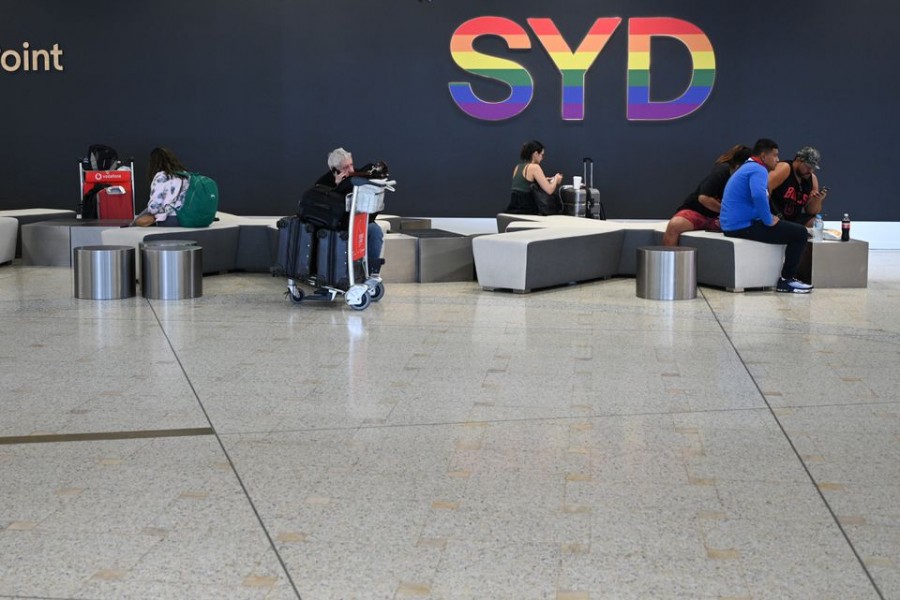 Travelers sit in the international terminal of Kingsford Smith International Airport the morning after Australia implemented an entry ban on non-citizens and non-residents intended to curb the spread of the coronavirus disease (COVID-19) in Sydney, Australia, March 21, 2020. REUTERS/Loren Elliott