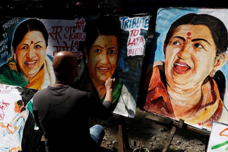 An artist paints a tribute to late Indian singer and music composer Lata Mangeshkar after she passed away, in Mumbai, India, February 6, 2022. Reuters