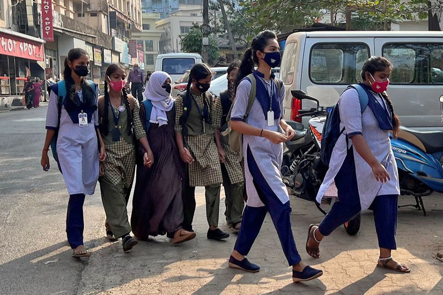 A Hijab wearing schoolgirl holds hands of her classmates as she arrives to attend the classes at a government girls school after the recent hijab ban, in Udupi town in the southern state of Karnataka, India on February 16, 2022 — Reuters photo