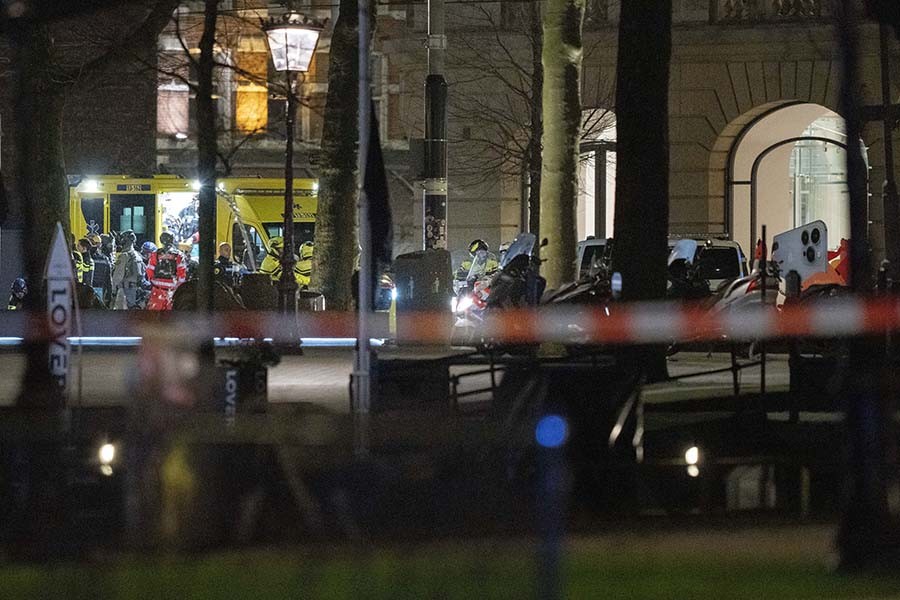 Police special intervention units and rescue workers are seen next to the Apple Store, two windows at right, in Amsterdam, Netherlands, Tuesday, Feb. 22, 2022, where an armed person was holed up in with at least one hostage in an hours-long standoff with scores of police massed outside. (AP Photo/Peter Dejong)