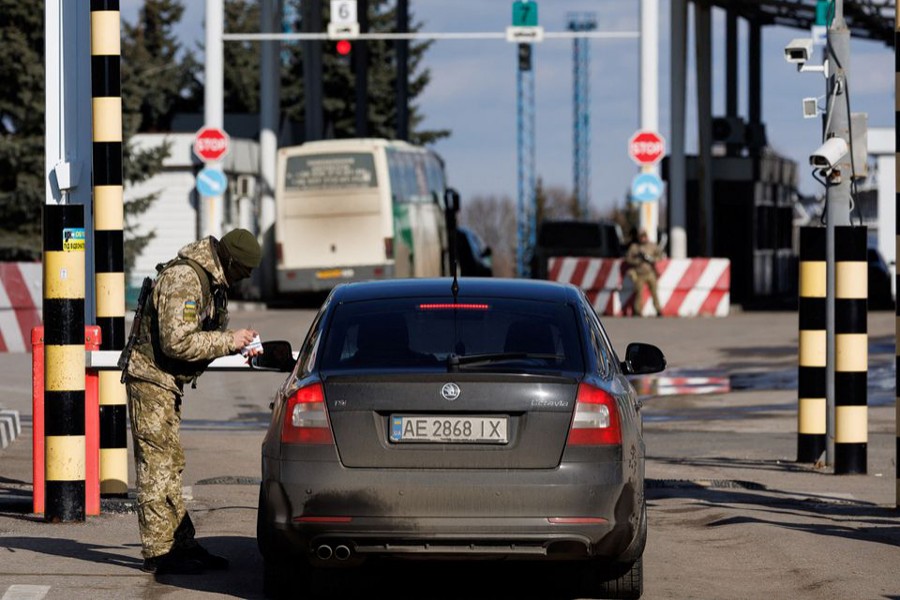 A Ukrainian frontier guard checks a man's documents at the Hoptivka (Goptovka) crossing on the Ukrainian-Russian border in the Kharkiv region, Ukraine on February 23, 2022 — Reuters photo