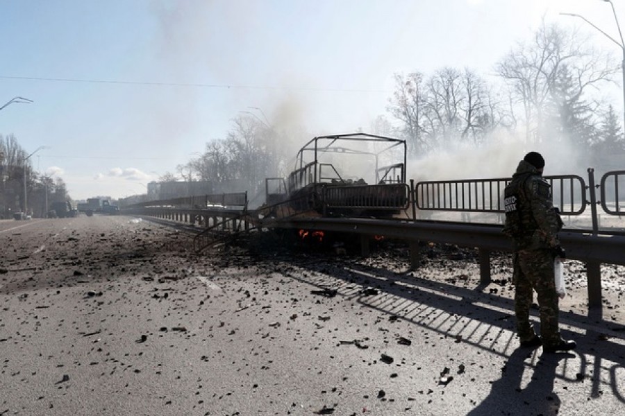 A Ukrainian serviceman walks by a damaged vehicle, at the site of a fighting with Russian troops after Russia launched a massive military operation against Ukraine, in Kyiv, Ukraine Feb 26, 2022 — Reuters