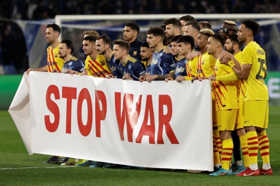 Napoli and FC Barcelona players display a 'Stop War' banner before a Europa League match [Ciro De Luca/Reuters]