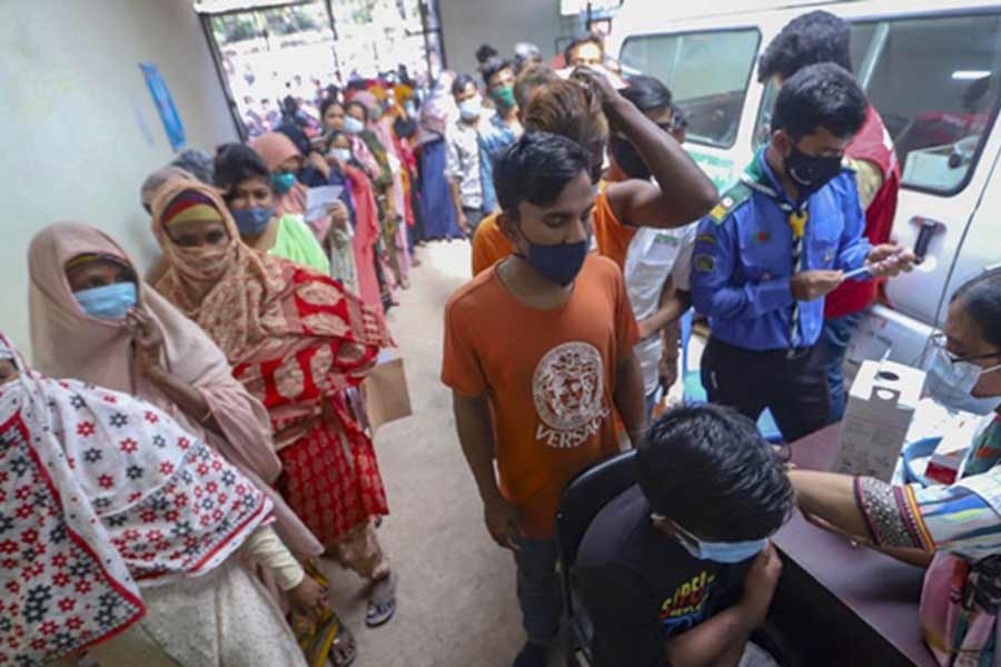 A man receiving a dose of the Covid-19 vaccine as others waiting in queues at Nagar Matrisadan centre in Dhaka’s Mugda during a nationwide mass inoculation drive on February 26 –bdnews24.com file photo