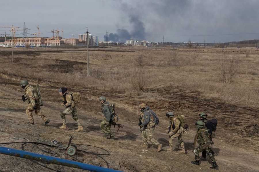 Ukrainian servicemen walk near a destroyed bridge as Russia's invasion of Ukraine continues, in the town of Irpin outside Kyiv, Ukraine, March 12, 2022. REUTERS/Marko Djurica