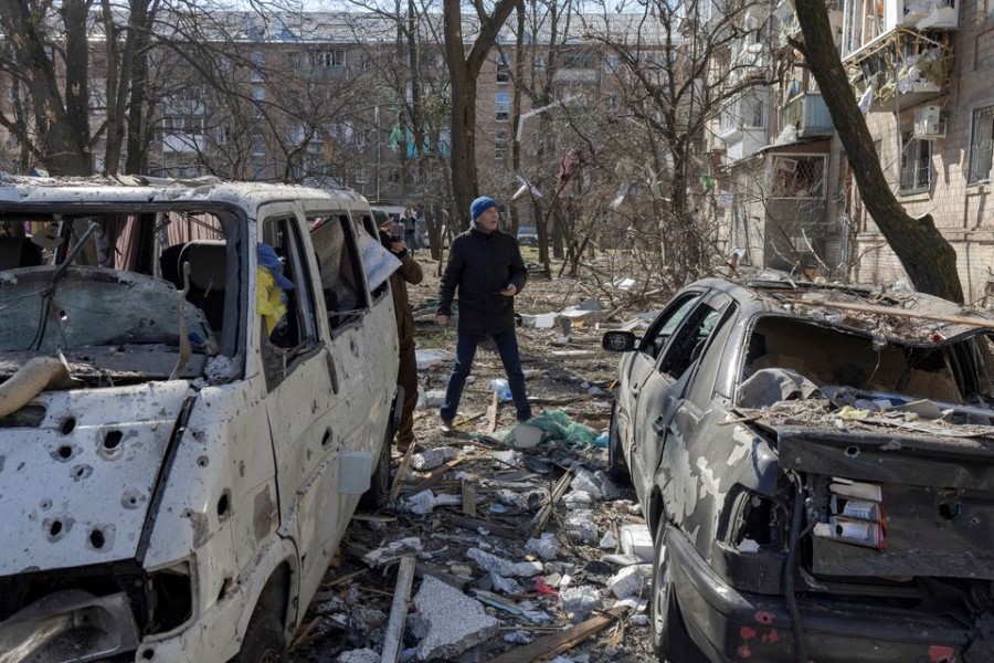 A man walks near destroyed cars in a residential district that was damaged by shelling, as Russia's invasion of Ukraine continues, in Kyiv, Ukraine, March 18, 2022. REUTERS/Marko Djurica