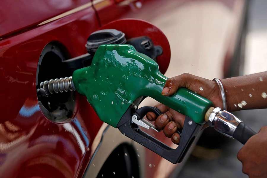 A worker holding a nozzle to pump petrol into a vehicle at a fuel station in Mumbai of India –Reuters file photo